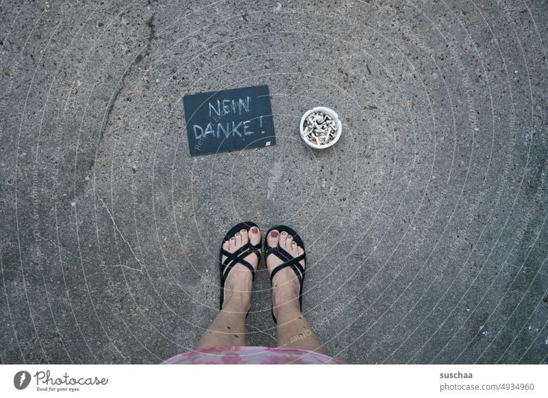 woman standing next to a filled ashtray with a plaque that reads " no thanks!" feet Legs feminine Flip-flops Summer Street Asphalt Ashtray Cigarette Butt