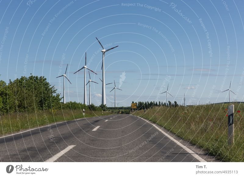 wind turbines appear on the horizon of a country road Brandenburg Energy wind power Wind energy plant Renewable energy Energy industry Pinwheel Eco-friendly