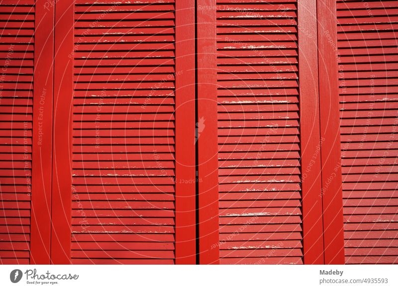Red painted old wooden shutters with slats in the sunshine in the old town of Blomberg in East Westphalia-Lippe Window quality decorations Wall (building)