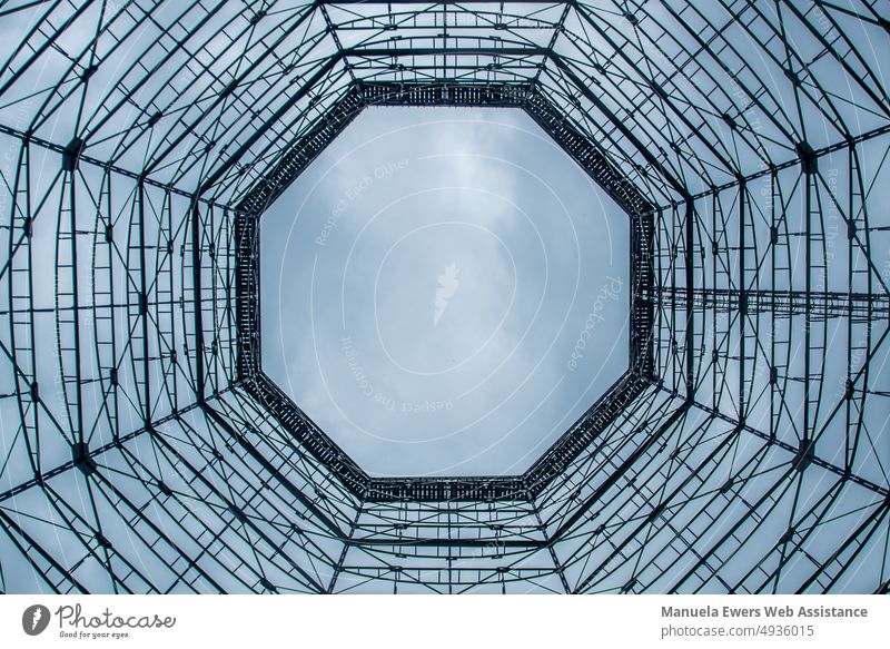 View from the inside of a cooling tower (chimney cooler in coal mining) Symmetry inboard cooling system octagon Sky Clouds somber background Coal Energy
