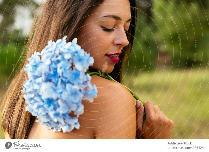 Lady with bunch of gentle hortensia flowers in park woman hydrangea smile topless cover breast feminine positive eyes closed nature happy bouquet female young