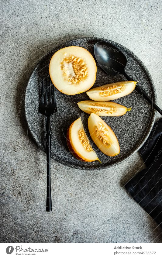 Black stoneware with mini melon slices dessert black ceramic cuttlery eat eating food healthy napkin organic plate ripe served summer sweet grey background