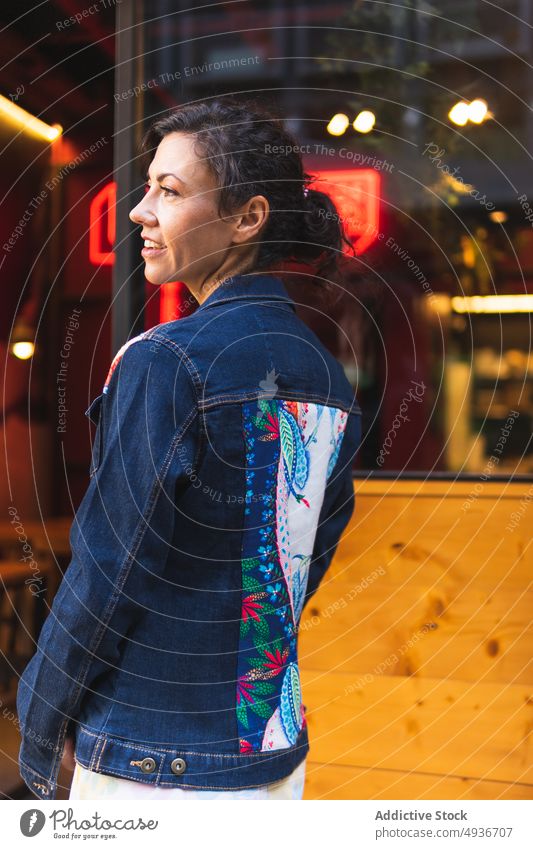 Woman standing near cafe on street woman city denim style pattern print feminine fashion urban appearance building gorgeous wear dark hair black hair cafeteria
