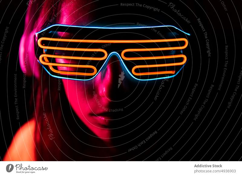 Futuristic woman listening to music at night futuristic red light neon illuminate meloman headphones female young brunette digital song headset sound dim melody