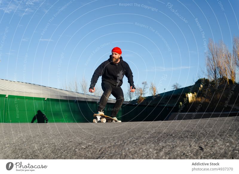 Man riding skateboard on pump track man skate park ride skater hipster hobby activity male energy motion cool beard recreation extreme guy balance practice