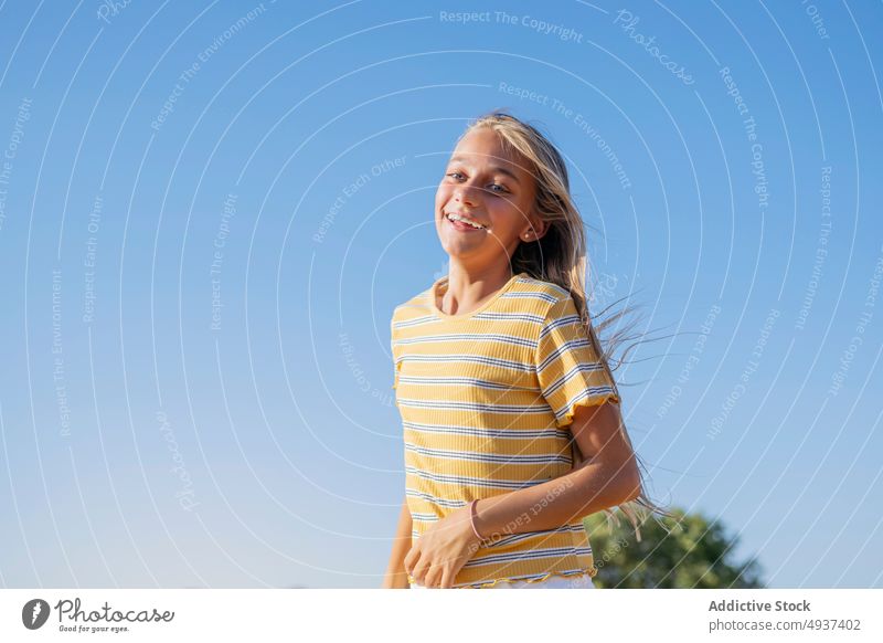 Content girl with flying hair teenage street appearance city carefree style smile wind glad blue sky summer positive portrait long hair cheerful happy