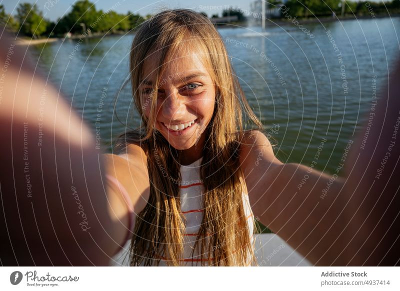 Girl taking selfie on embankment girl kid smartphone smile photography social media waterfront river capture memory moment content happy self portrait seafront