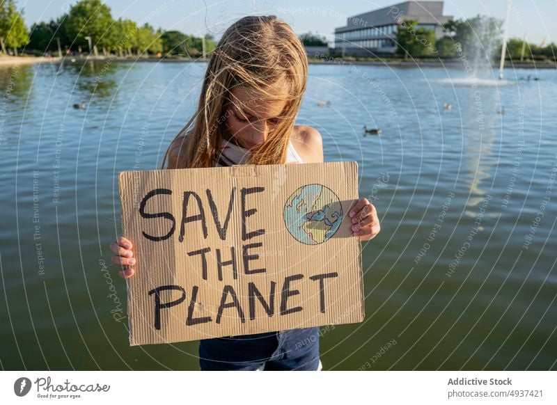Girl with Save The Planet sign near river girl save the planet water street activist ecology attention problem crisis teenage global announce environment poster