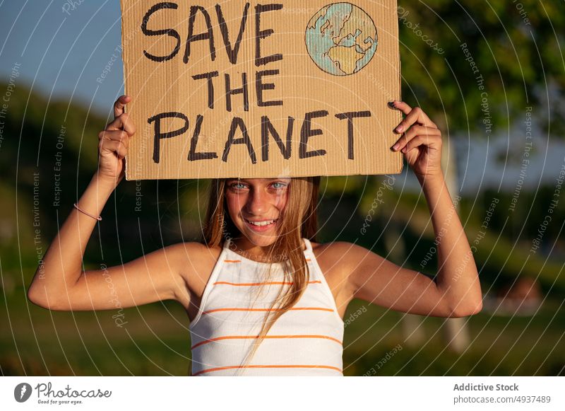 Girl with Save The Planet sign on street park girl save the planet activist ecology attention happy problem crisis teenage global announce environment smile