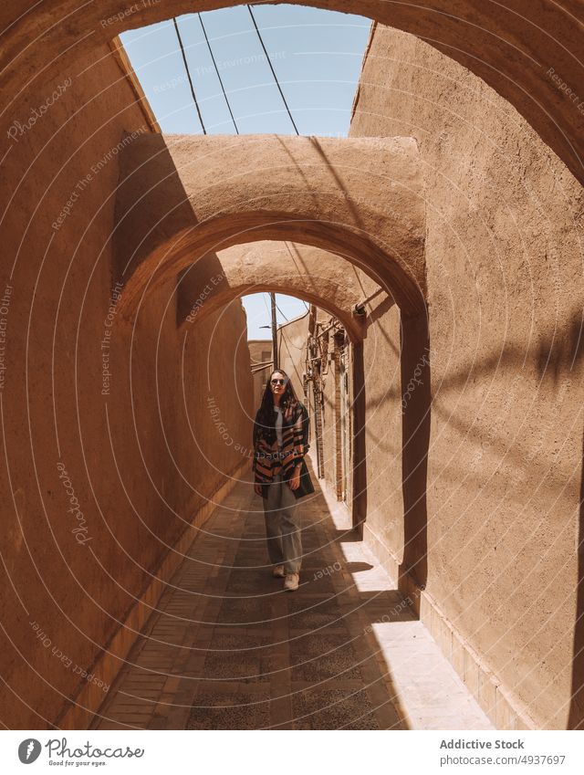 Serious woman standing in arched passage during sightseeing trip in Kerman historic ancient architecture admire tourist vacation holiday building female young