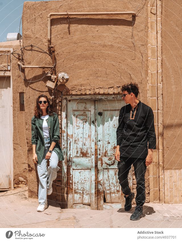 Young stylish couple standing near old building during trip in Iran together travel relationship tourist town style vacation ancient explore city boyfriend