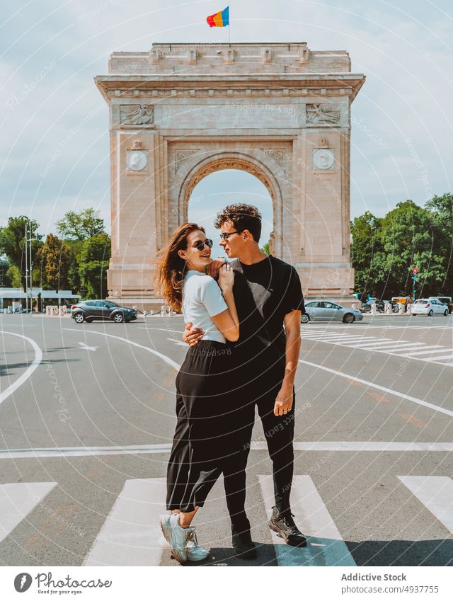 Young traveling couple embracing each other near Triumphal arch holding hands triumphal arch trip sightseeing happy romantic love together traveler hug walk
