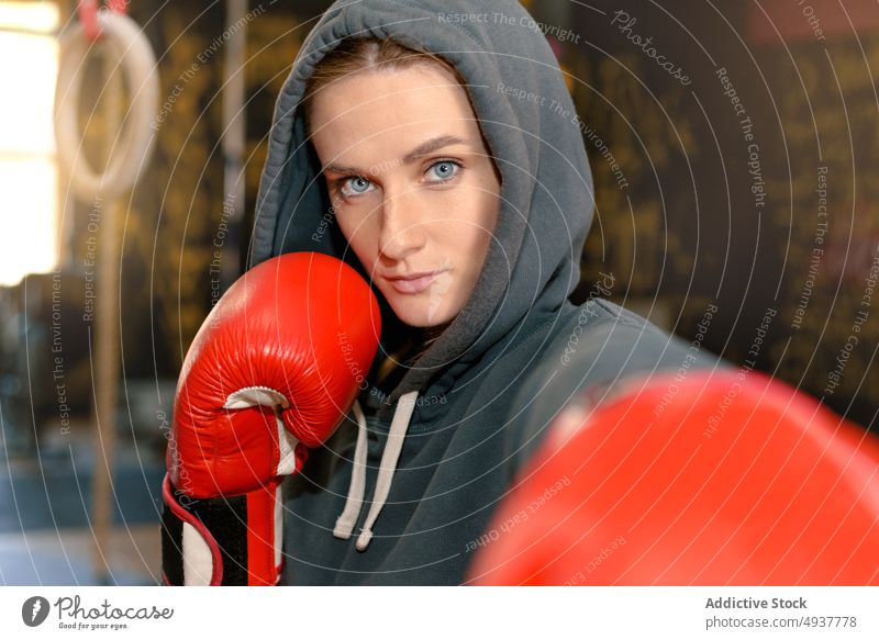 Female boxer punching camera sportswoman boxing training gym serious strong athlete female young workout power strength fighter activity endurance motivation