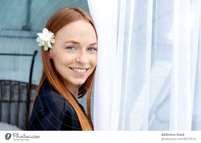 Cheerful redhead woman in spa salon smile client resort curtain rest happy weekend female young ginger long hair flower robe silk daytime customer wellness