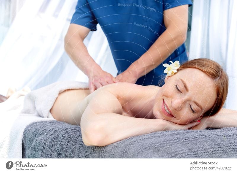 Woman smiling and closed eyes during massage client red hair masseur spa resort weekend happy smile session procedure woman wellness treat therapy skin care