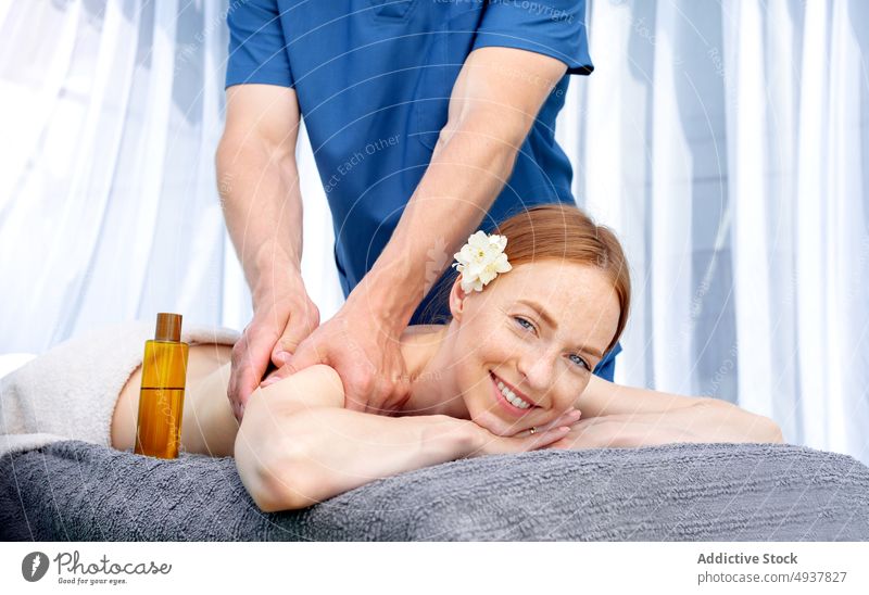 Woman looking at camera during massage client red hair masseur spa resort weekend happy smile session oil procedure woman wellness treat therapy skin care