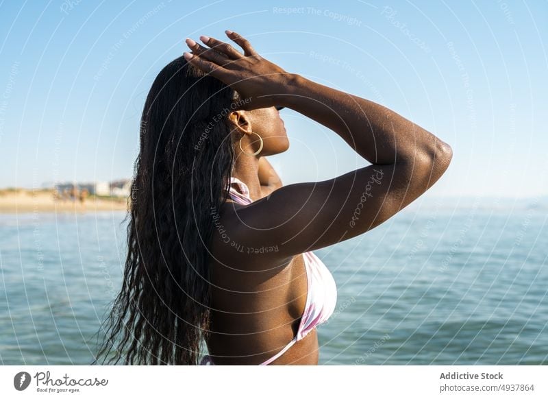Black woman standing in sea water resort vacation swimsuit summer blue sky female morning black african american ethnic swimwear ocean cloudless sky activity