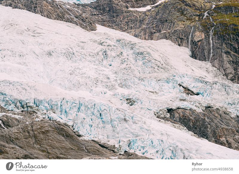 Jostedalsbreen National Park, Norway. Close Up View Of Melting Ice And Snow, Small Waterfall On Boyabreen Glacier In Spring Sunny Day. Famous Norwegian Landmark And Popular Destination. Close Up