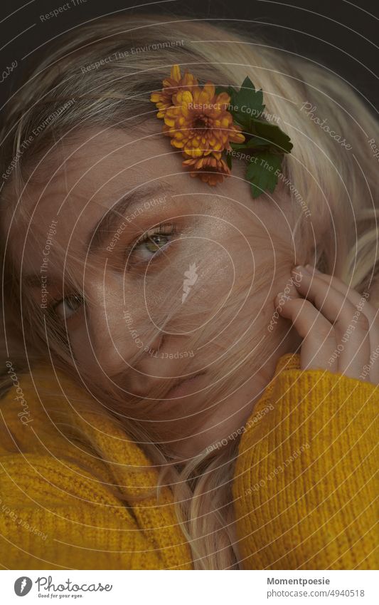 blonde woman with yellow knitted sweater and yellow flowers in hair looks at camera Blonde Remember Yellow Orange Flower Hair accessories Hair colour