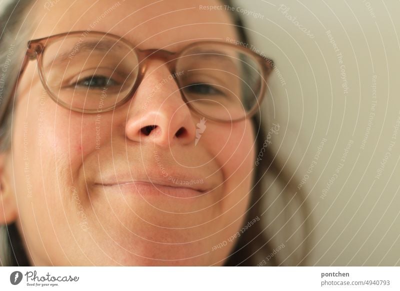 Knowing, amused facial expression of a woman with glasses. Smile, grin Looking Facial expression knowing Amused Grinning smart aleck Joy Brash Laughter