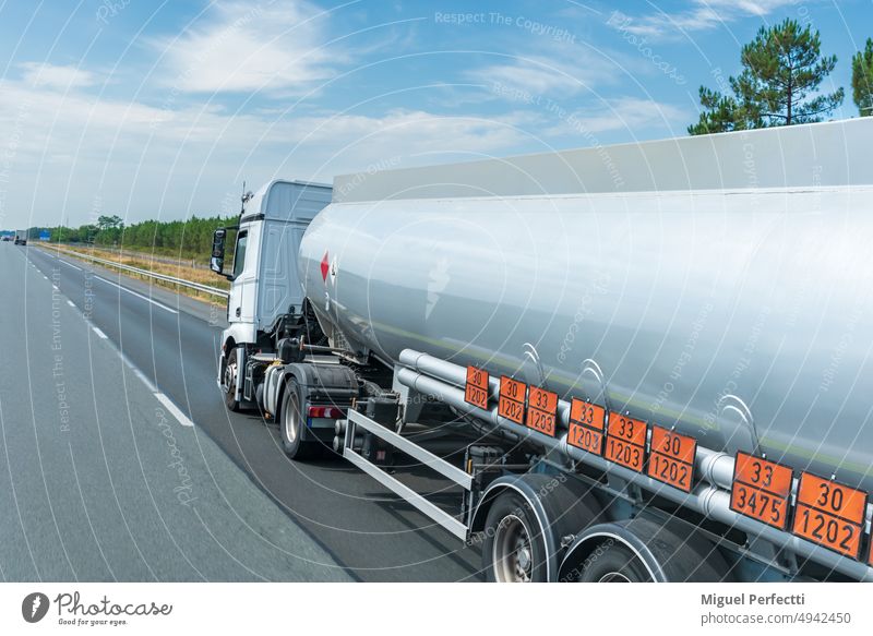 Fuel tanker truck circulating on the highway with orange panels identifying the danger and merchandise transported, transport under ADR regulations. traffic