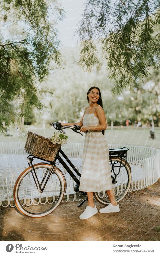 Young woman with flowers in the basket of electric bike active activity adult beautiful bicycle caucasian cycling day ebike exercise female flower basket