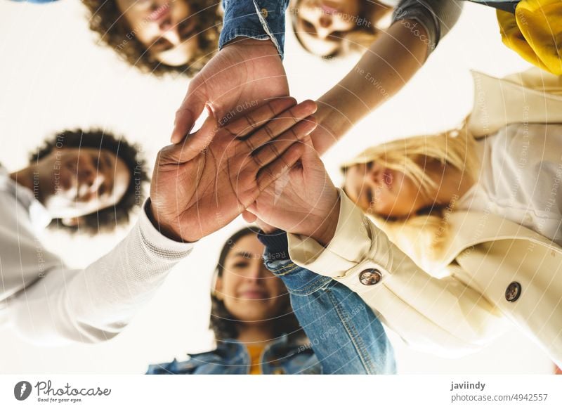 Diverse people stacking hands together stack hands join hands friend group trust team unity company diverse multiracial multiethnic hispanic black