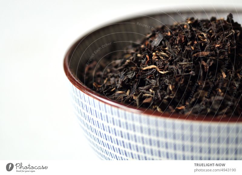 Black organic Assam (SFTGFOP1) tea dried from the Indian tea garden Tonganagaon second plucking (second flush) in a subtly patterned ceramic bowl ready to infuse