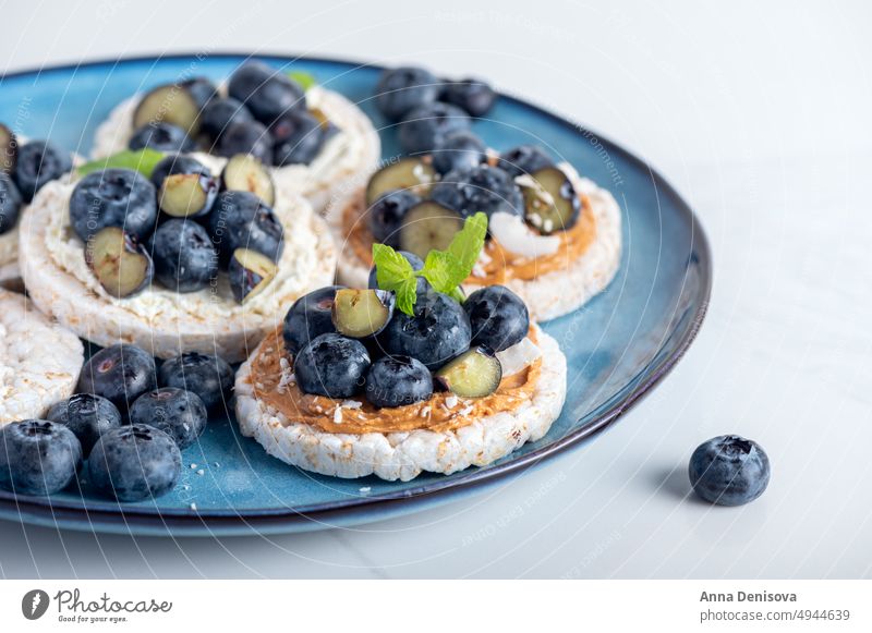 Healthy open sandwiches with blueberries rice crisps blueberry peanut butter healthy snack rice cakes crackers almond cashew mint appetizer vegan tasty toast