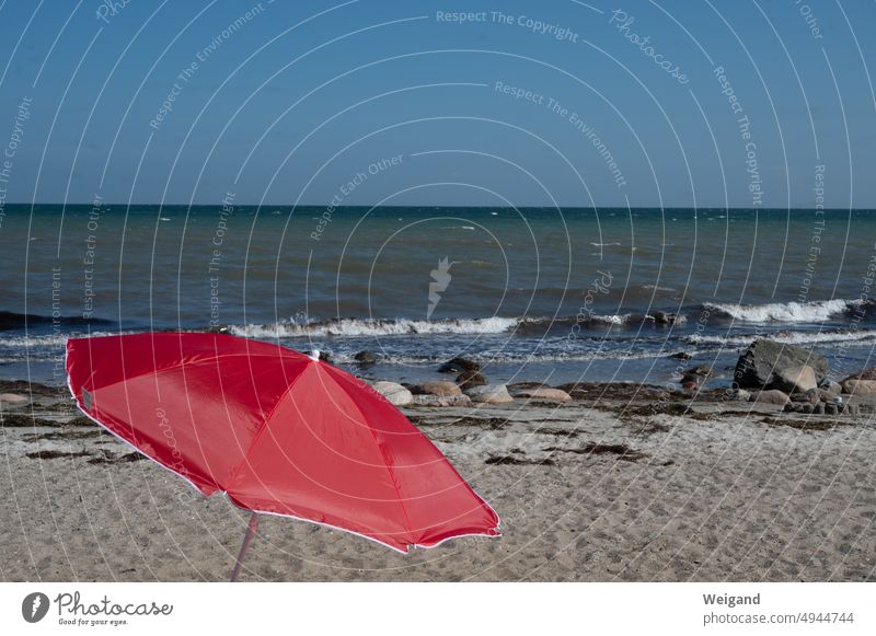 Red parasol on the beach of the Baltic Sea Sunshade Beach North Sea Northern Germany Schleswig-Holstein Sandy beach pebble stones Summer Ocean relaxation