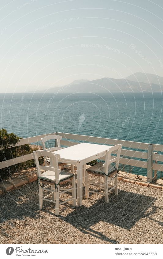 Table and chair set in Greek restaurant with wide view over the sea to the mountains Exterior shot Restaurant Terrace Table and chairs Greece Gastronomy Empty