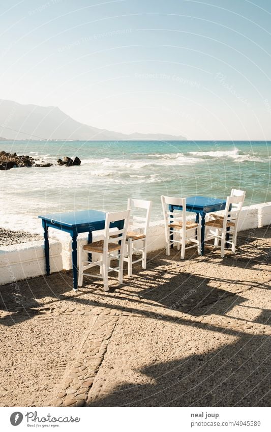 Terrace of a greek restaurant directly at the sea with view to the mountains Exterior shot Restaurant Table and chairs Greek Greece Gastronomy Empty Deserted