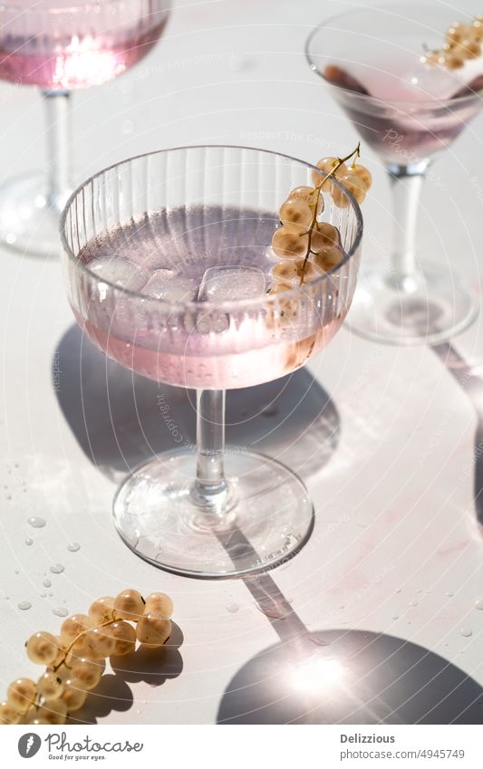 pink drinks decorated with withe currants, white background- cocktail food serve fruit fresh raw isolated no people alcohol tasty pale backdrop three bunch