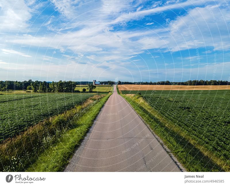 Empty rural road in wisconsin grass sunny natural nature day background agriculture summer drone sustainable resources agricultural field silo outdoors