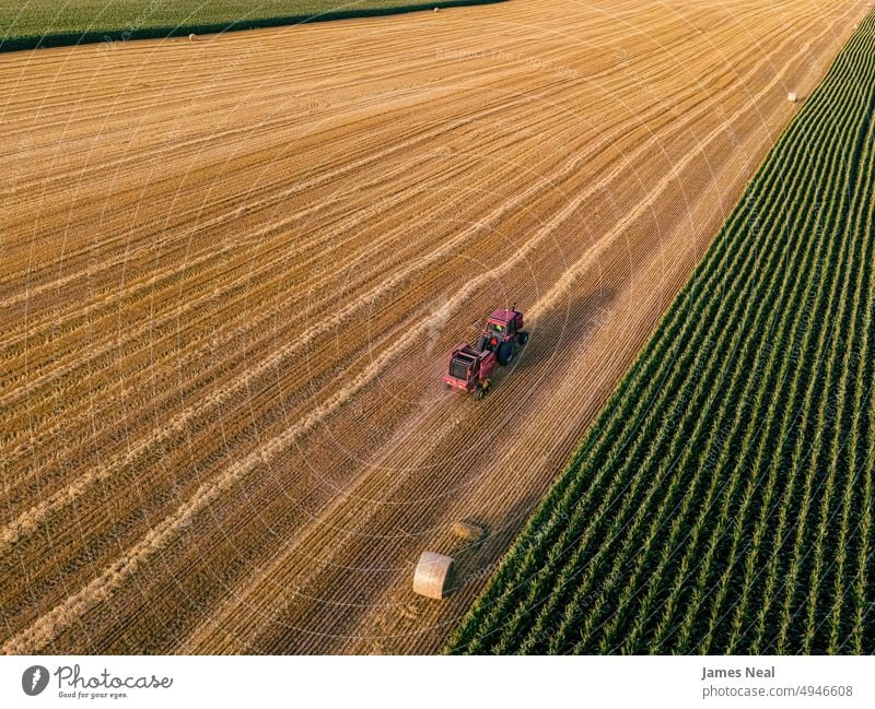 Tractor heading down the field grass Agricultural Machinery natural nature day background red agriculture corn plant drone sustainable resources
