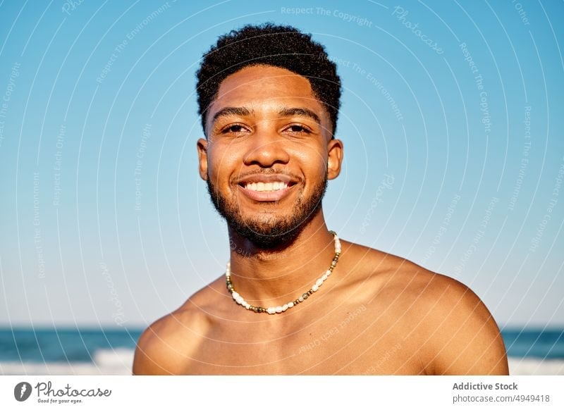 African American man standing on sea smile beach wave weekend portrait tourist male african american ethnic young vacation resort coast summer cloudless sky