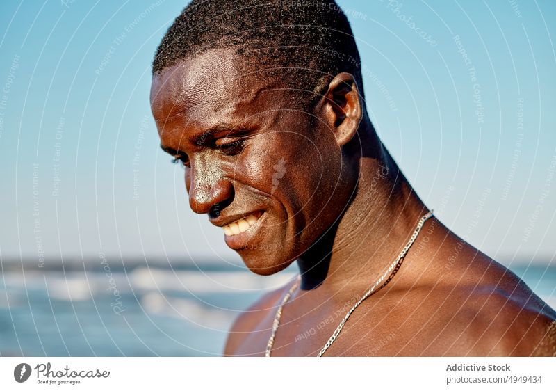 Cheerful black male smiling near sea man smile beach happy weekend summer blue sky cheerful water african american ethnic friendly carefree positive holiday