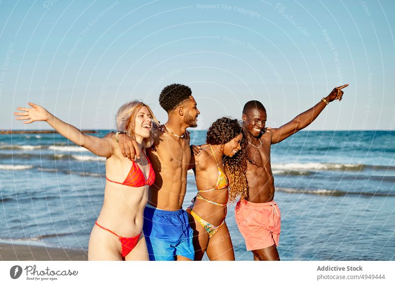 Diverse friends hugging and walking near sea beach happy smile together weekend summer men women diverse multiethnic multiracial african american black glad