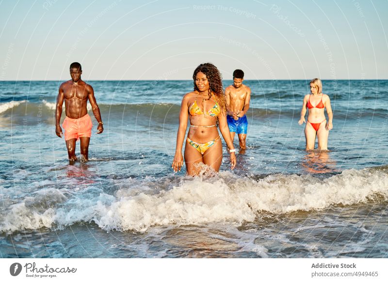 Diverse men and women in sea friend walk wave sunset having fun weekend summer together diverse multiracial multiethnic black african american girlfriend