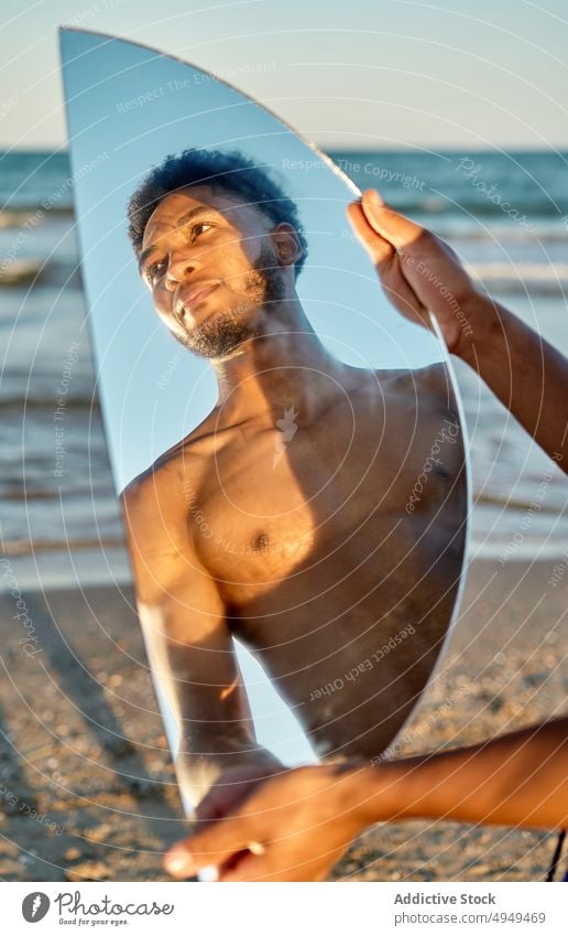 Black man with mirror near sea beach reflection summer weekend semicircle holiday resort male young black african american ethnic shirtless naked torso vacation
