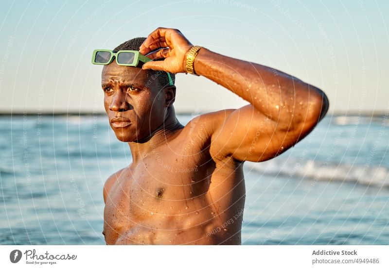 Shirtless black man in sea water weekend summer adjust sunglasses shirtless vacation clean male muscular young african american ethnic tourist recreation fit