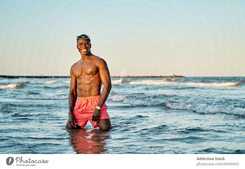 Shirtless smiling black man in sea water - a Royalty Free Stock Photo from  Photocase