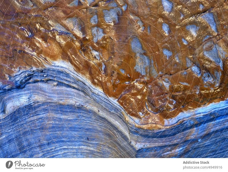 Surface of blue and brown metamorphic rock abstract ornament smooth wavy background texture natural surface material mineral fragment uneven effect curve detail