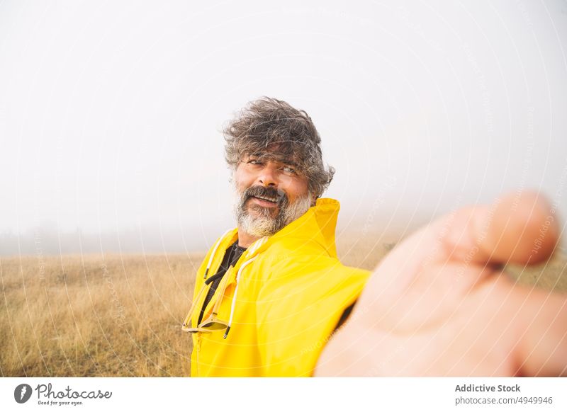Happy mature hiker taking selfie in foggy valley man smile morning wind happy carefree irati navarre spain male middle age mist countryside weather glad memory