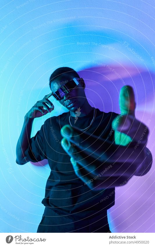 Confident black man in futuristic headset reaching out hand to camera reach out virtual reality digital serious vr cyberspace portrait innovation experience