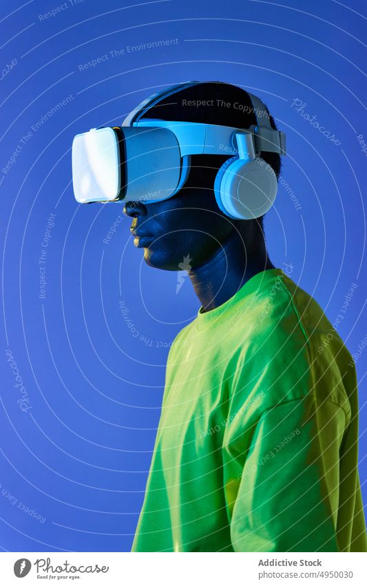 Concentrated black man watching video in VR goggles virtual reality experience explore futuristic cyberspace vr portrait simulator simulate male young