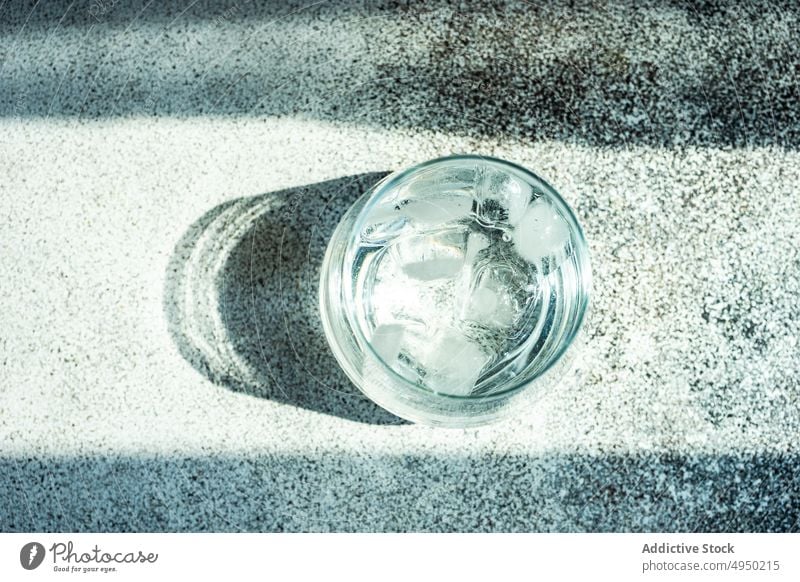 Glass of clear water with ice background beverage concrete drink glass cube liquid shadow summer transparent table cold refreshment kitchen crystal indoors