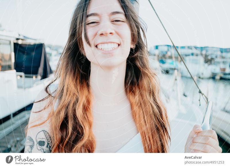 Close up portrait of Young woman enjoying summer vacation next to her yacht.luxurious yacht cruise, sea travel by luxury boat.Young happy woman on boat deck sailing the sea. Yachting in Greece,Spain