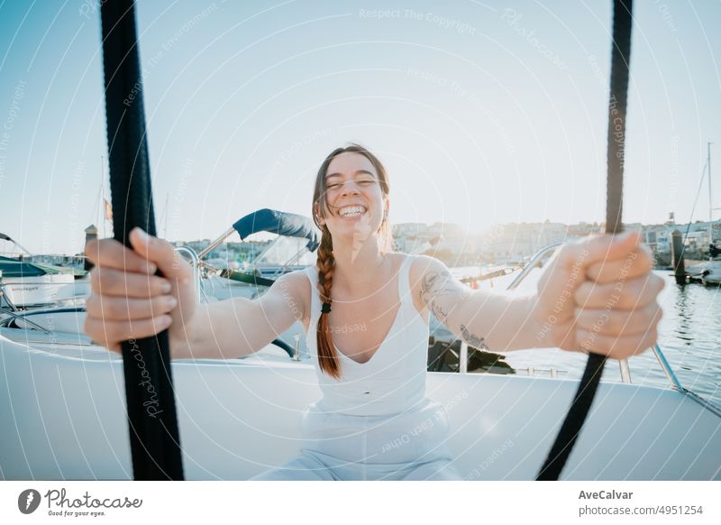 Young woman enjoying summer vacation next to her yacht.luxurious yacht cruise, sea travel by luxury boat.Young happy woman on boat deck sailing the sea. Yachting in Greece,Spain. sunset time