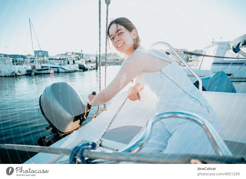 Young woman preparing a yacht motorboat to take travel enjoying summer vacation.luxurious yacht cruise, sea travel by luxury boat.Young happy woman on boat deck sailing the sea. Yachting in Greece